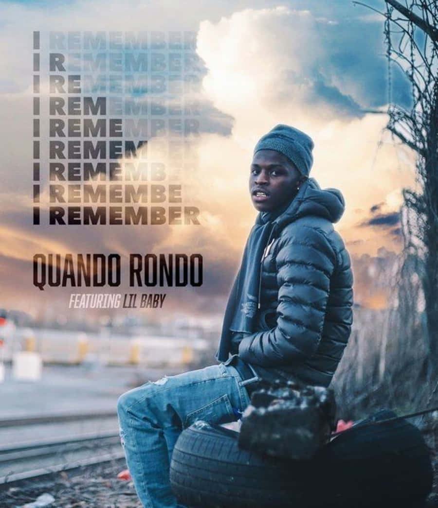 Quando Rondo Striking A Pose With His Stylish Outfit And Colorful Backdrop Background