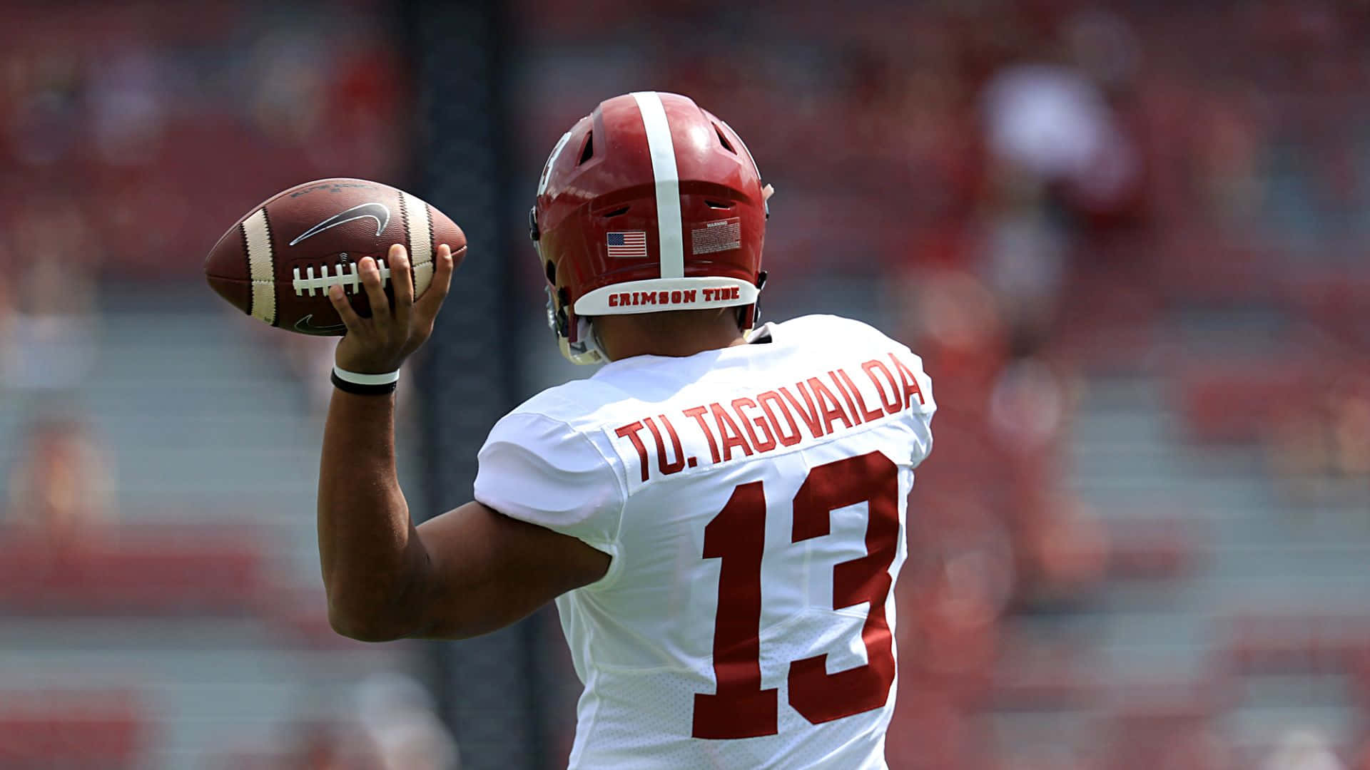 Quarterback Tua Tagovailoa Showing Off His University Of Alabama Helmet Background