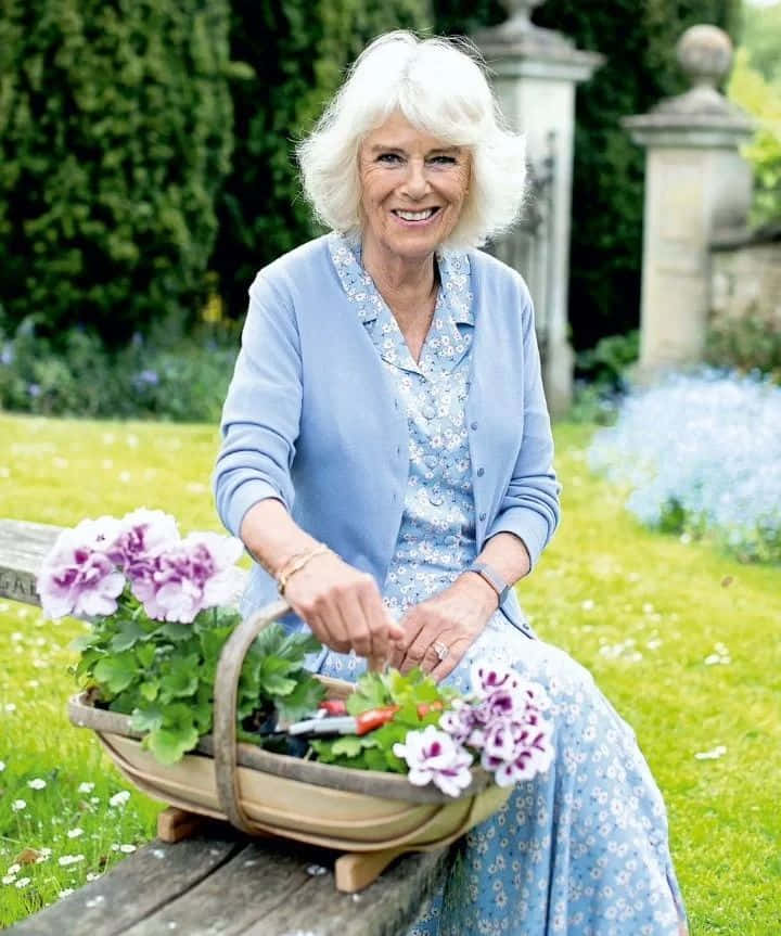 Queen Camilla Gracefully Holding A Flower Basket