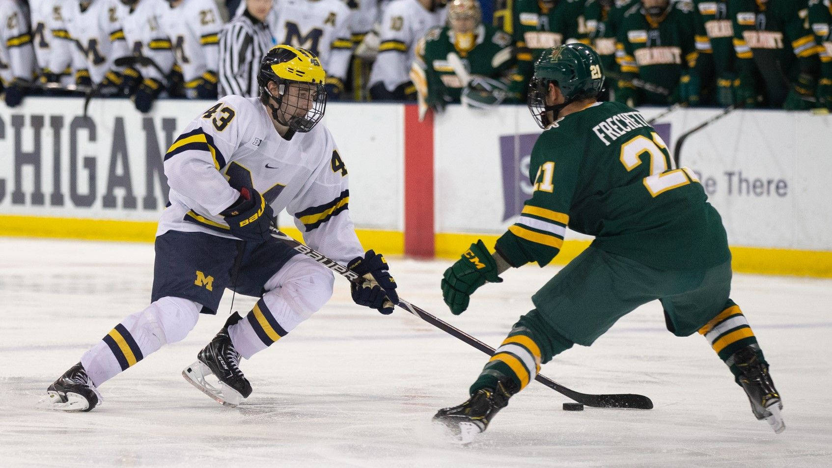 Quinn Hughes Dribbling Against Player From University Of Vermont Background