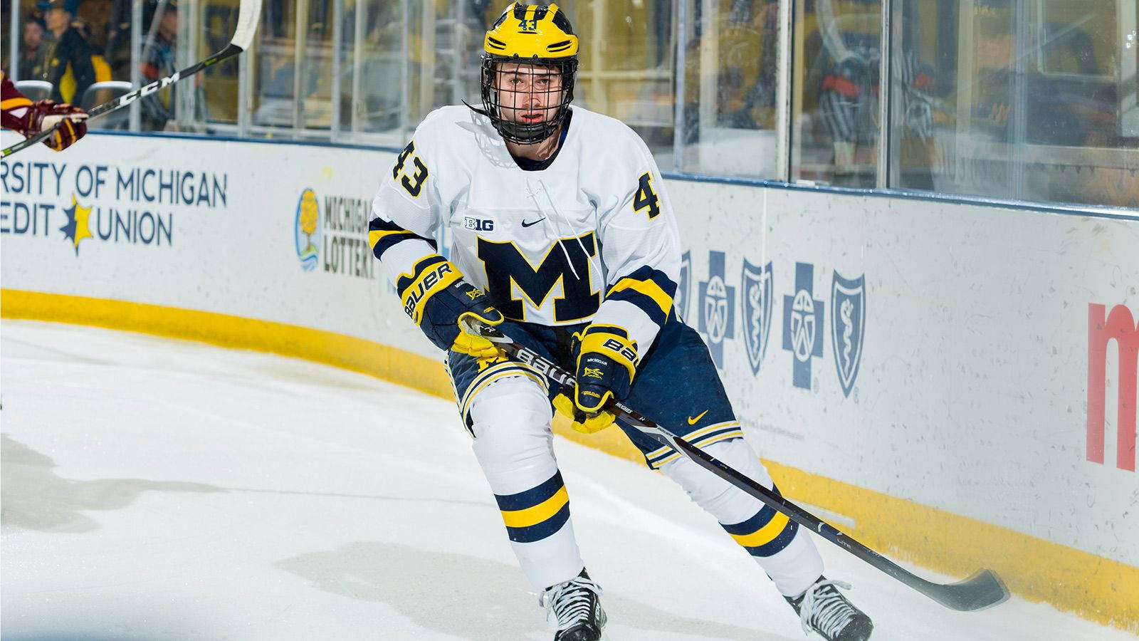 Quinn Hughes Leaning To The Right While Holding Hockey Stick Background