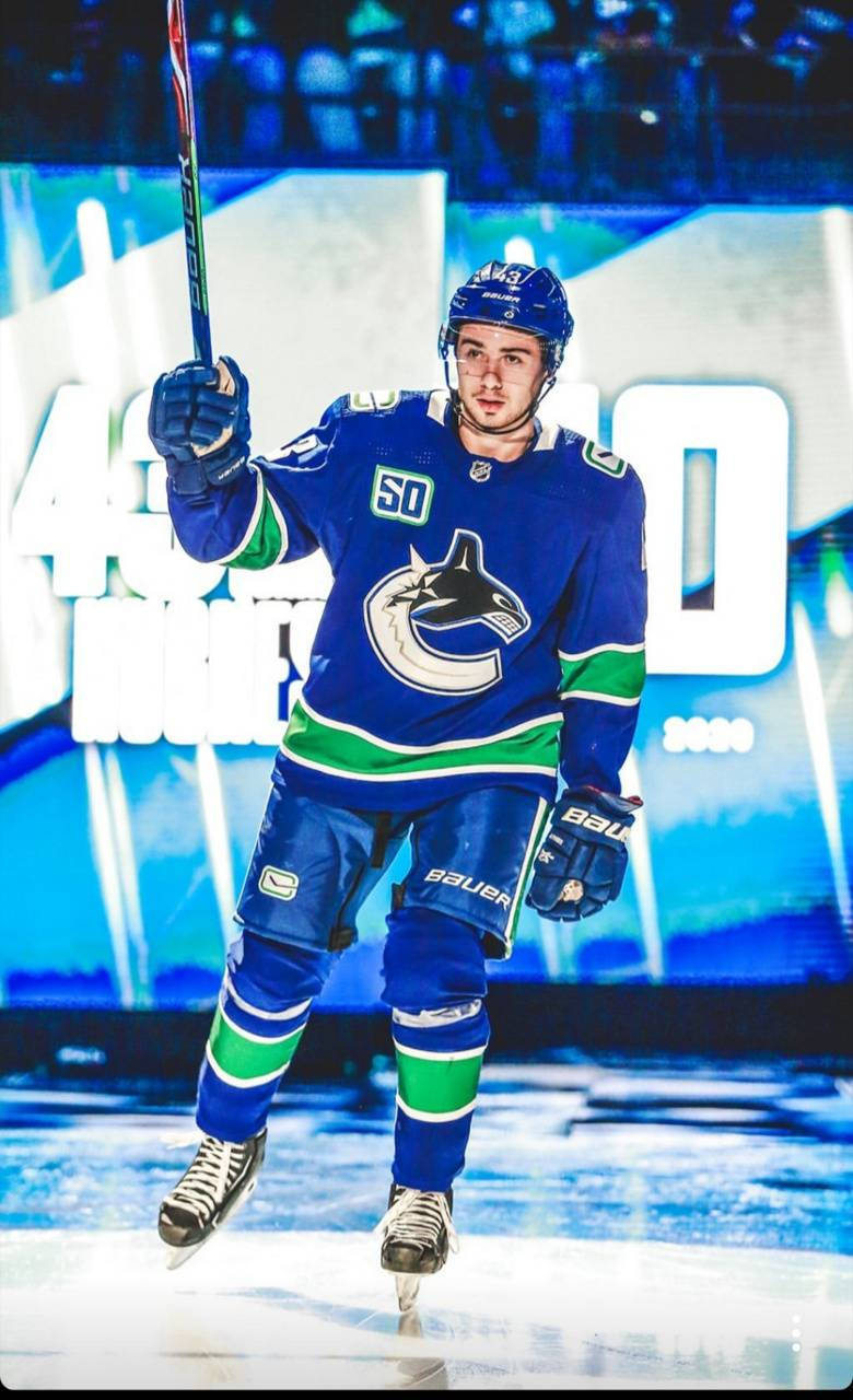 Quinn Hughes Straight Face While Holding Hockey Stick In The Air Background