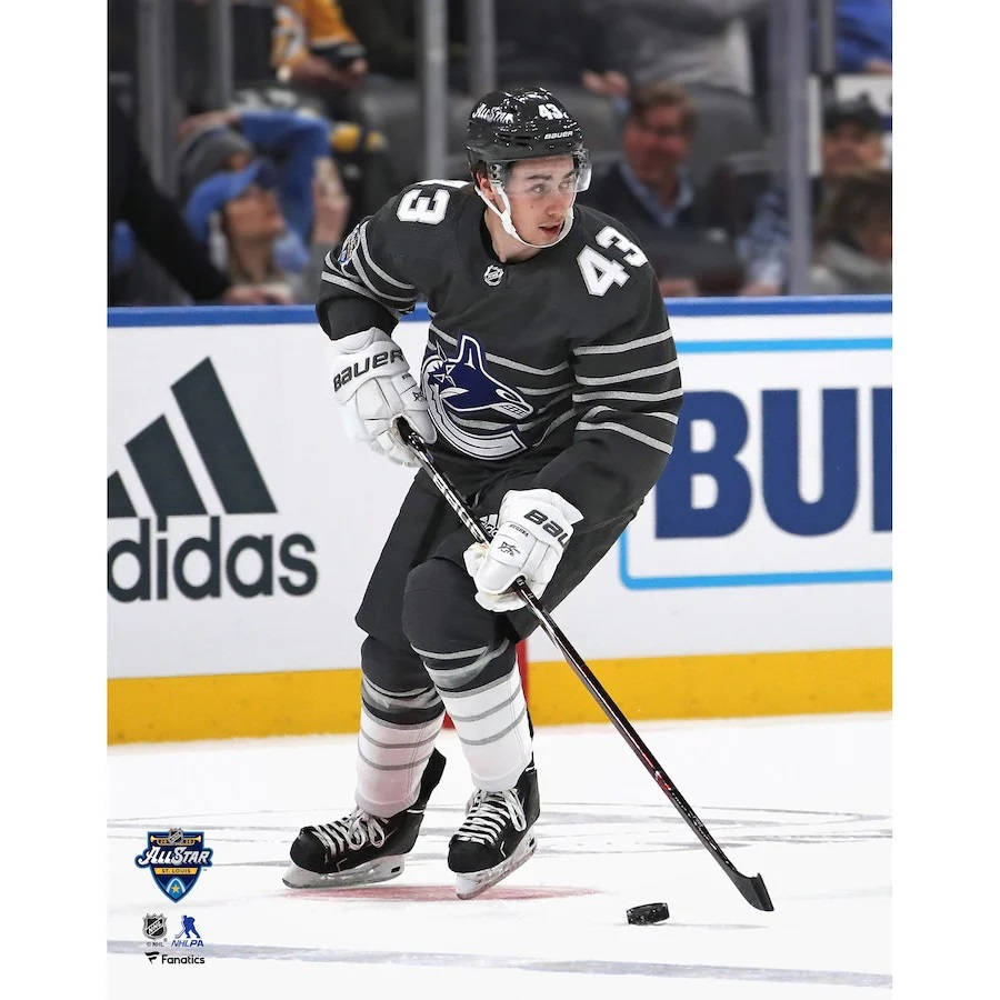 Quinn Hughes Wearing Black Jersey Dribbling Hockey Puck Background