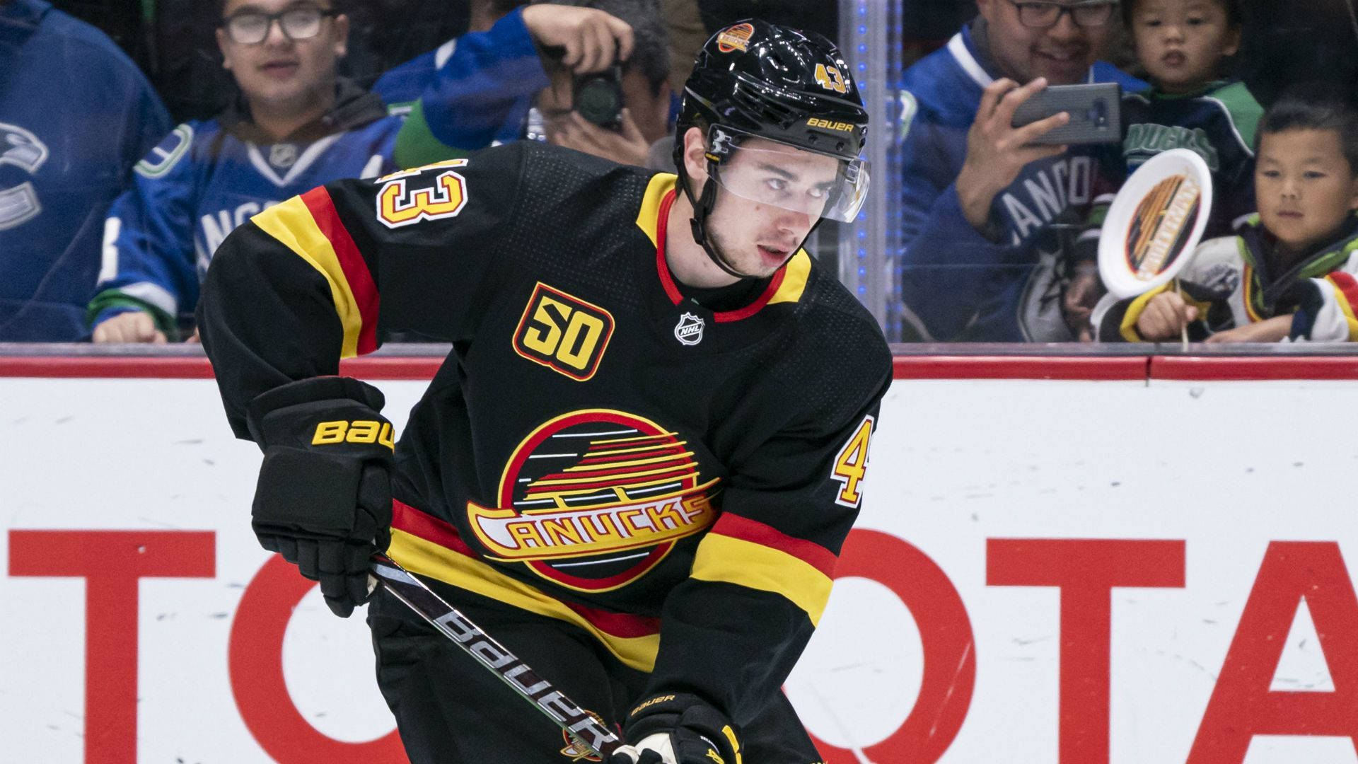 Quinn Hughes Wearing Old Jersey While Focusing On The Game Background