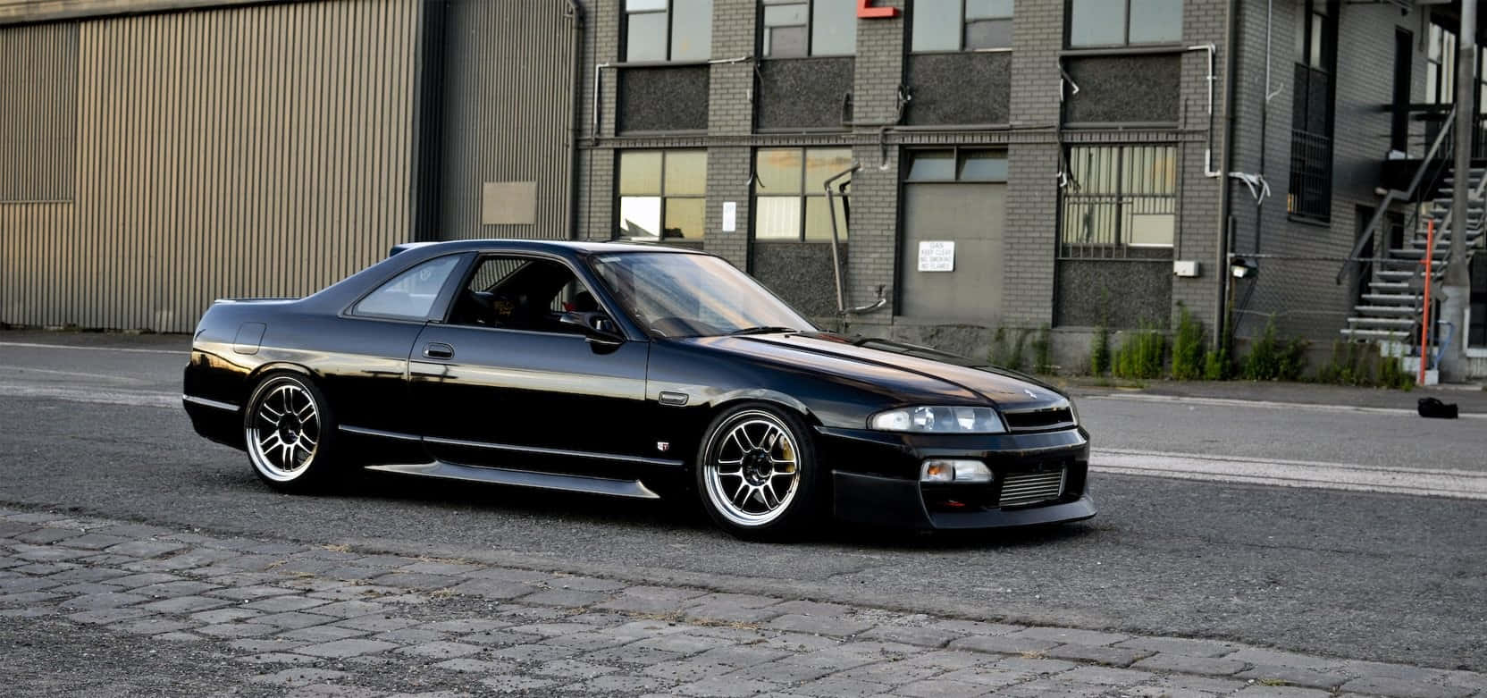 R33 Gtr Driving On City Street Background