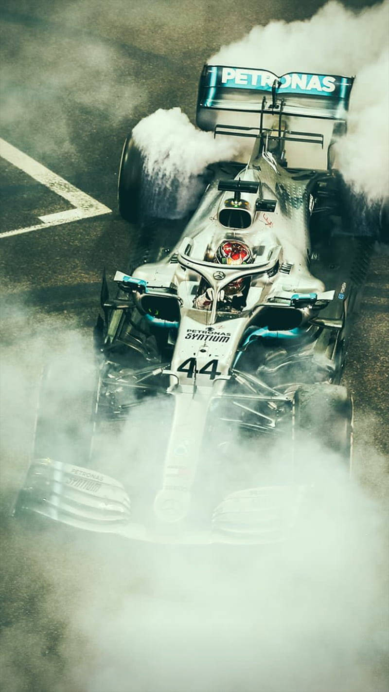 Race Car Of Lewis Hamilton F1 Covered With Smoke Background