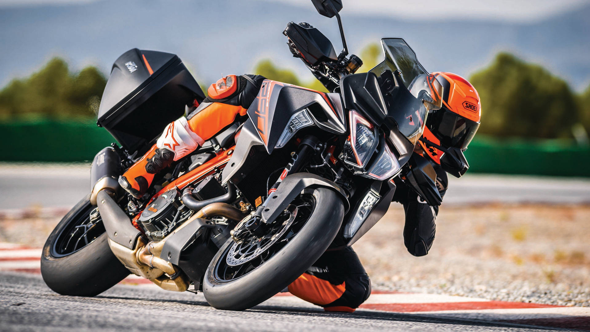 Racer Hanging Off A Ktm Duke 200 Background