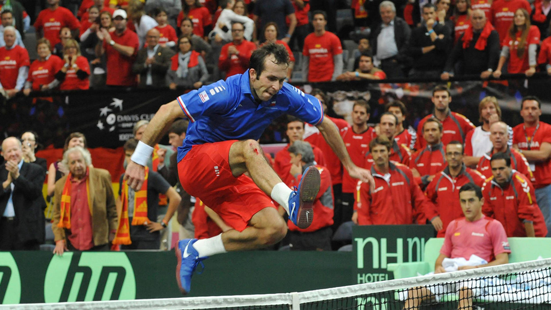 Radek Stepanek Jumping Over Tennis Net Background