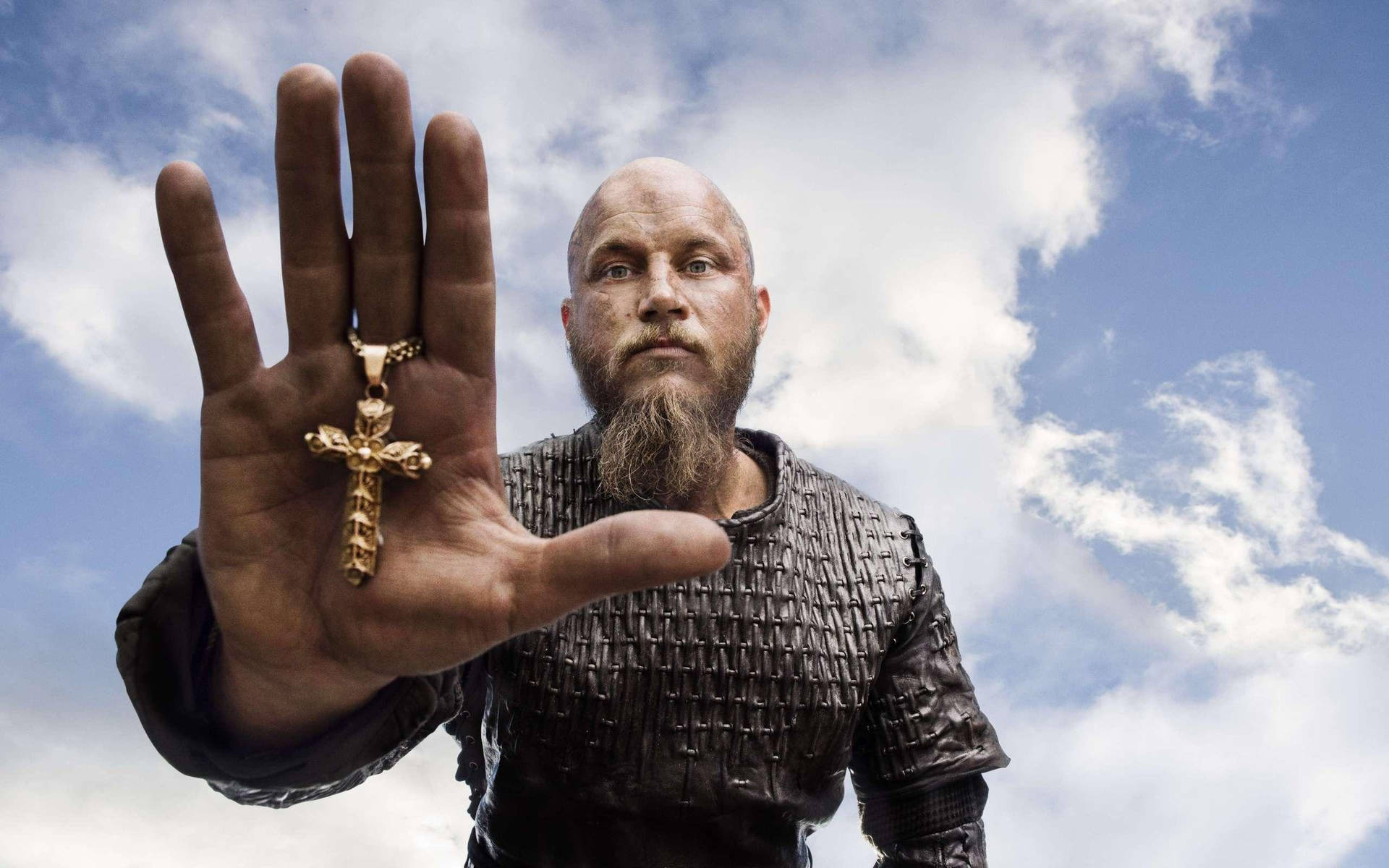 Ragnar Lothbrok From Vikings Holding Cross Background