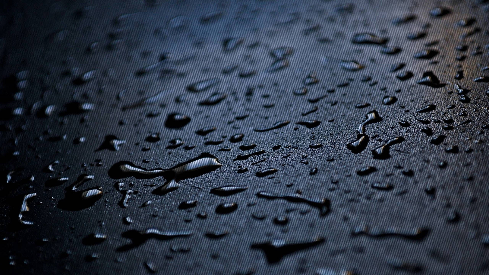 Raindrops And Water Splashes On A Black Surface Background