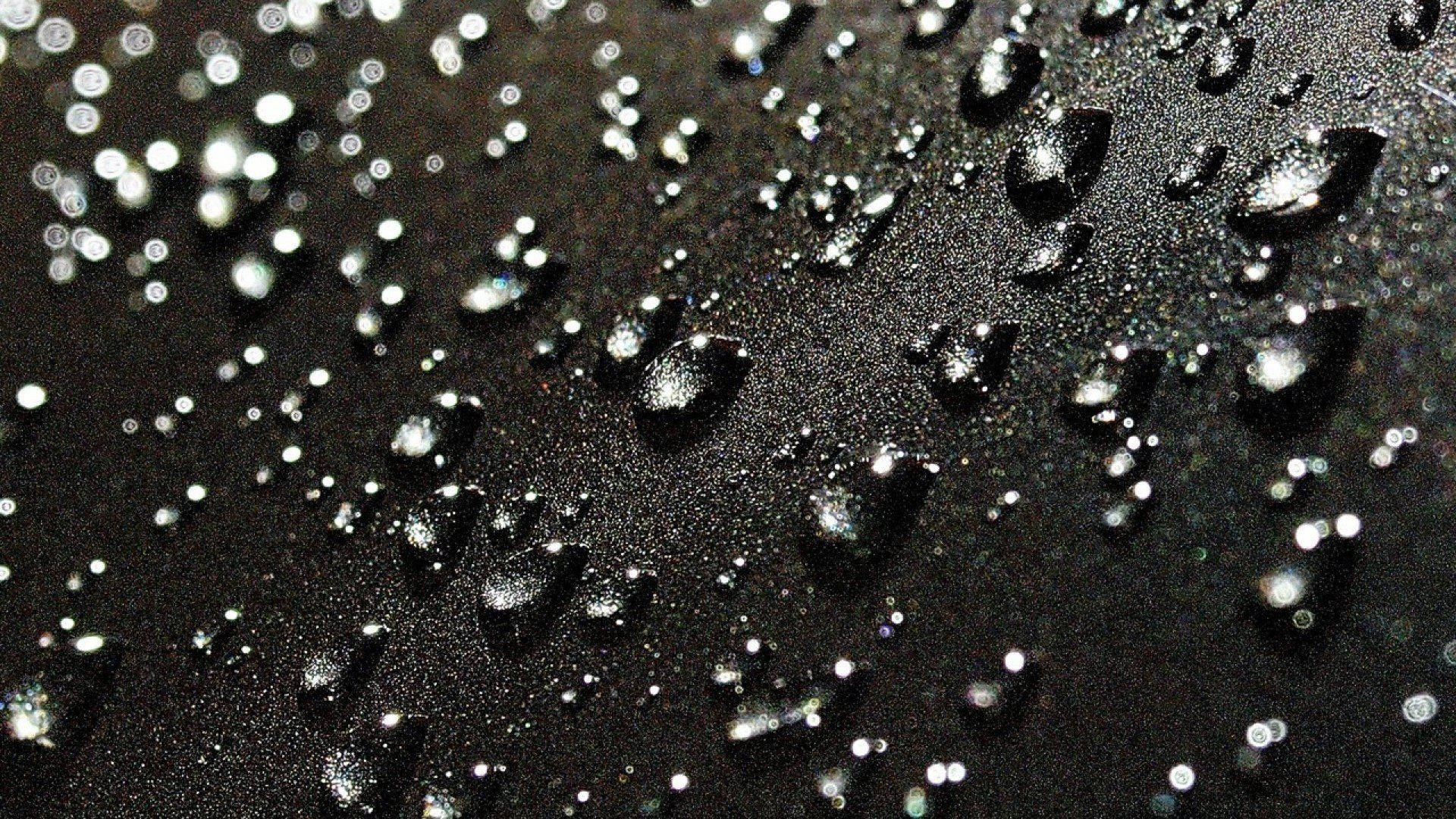 Raindrops Falling On A Deep Black Surface Background
