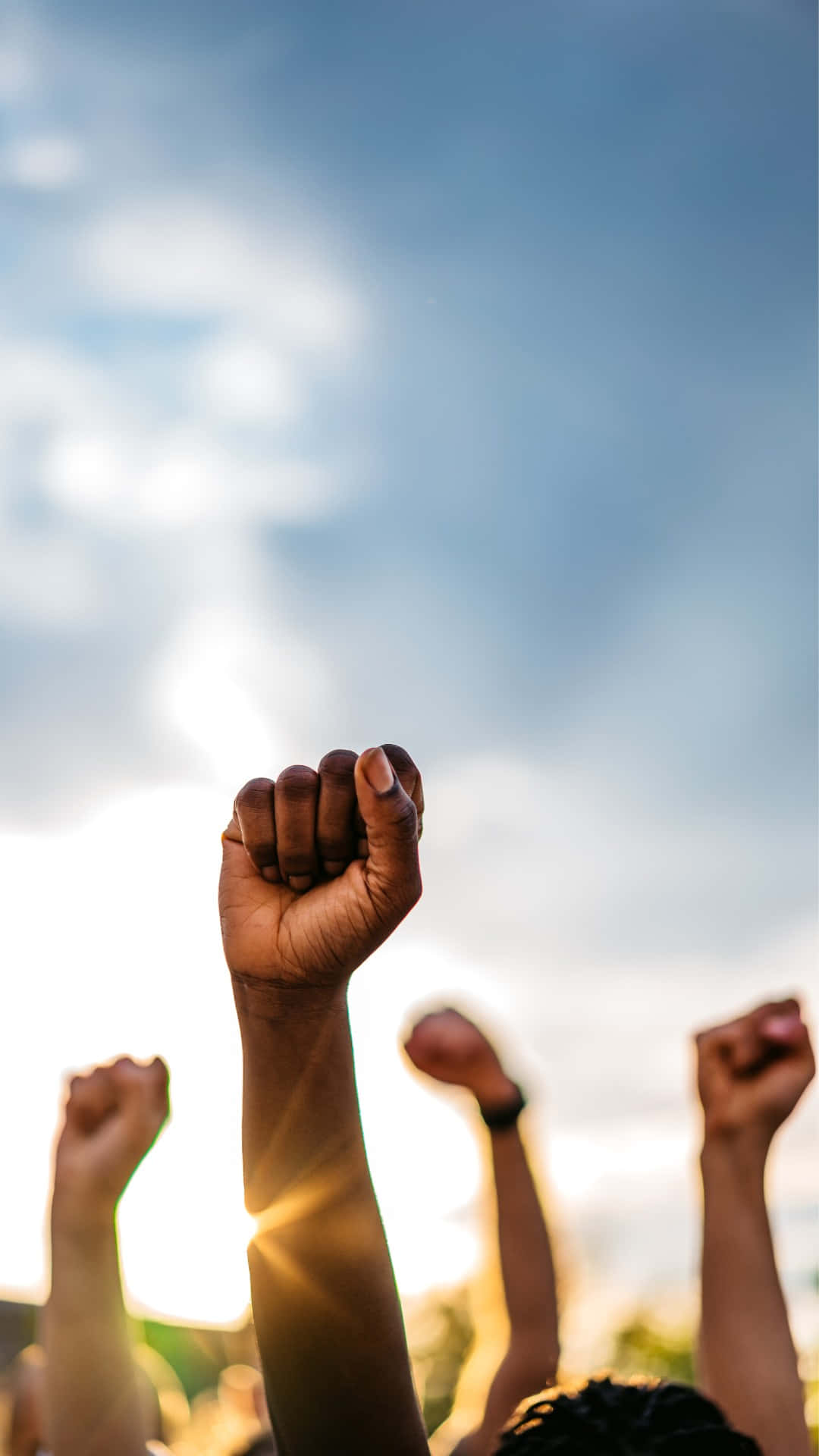 Raised Fists Against Sky Protest Solidarity Background