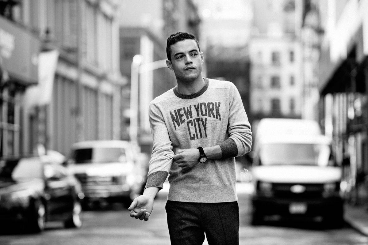 Rami Malek Standing In The Street Background