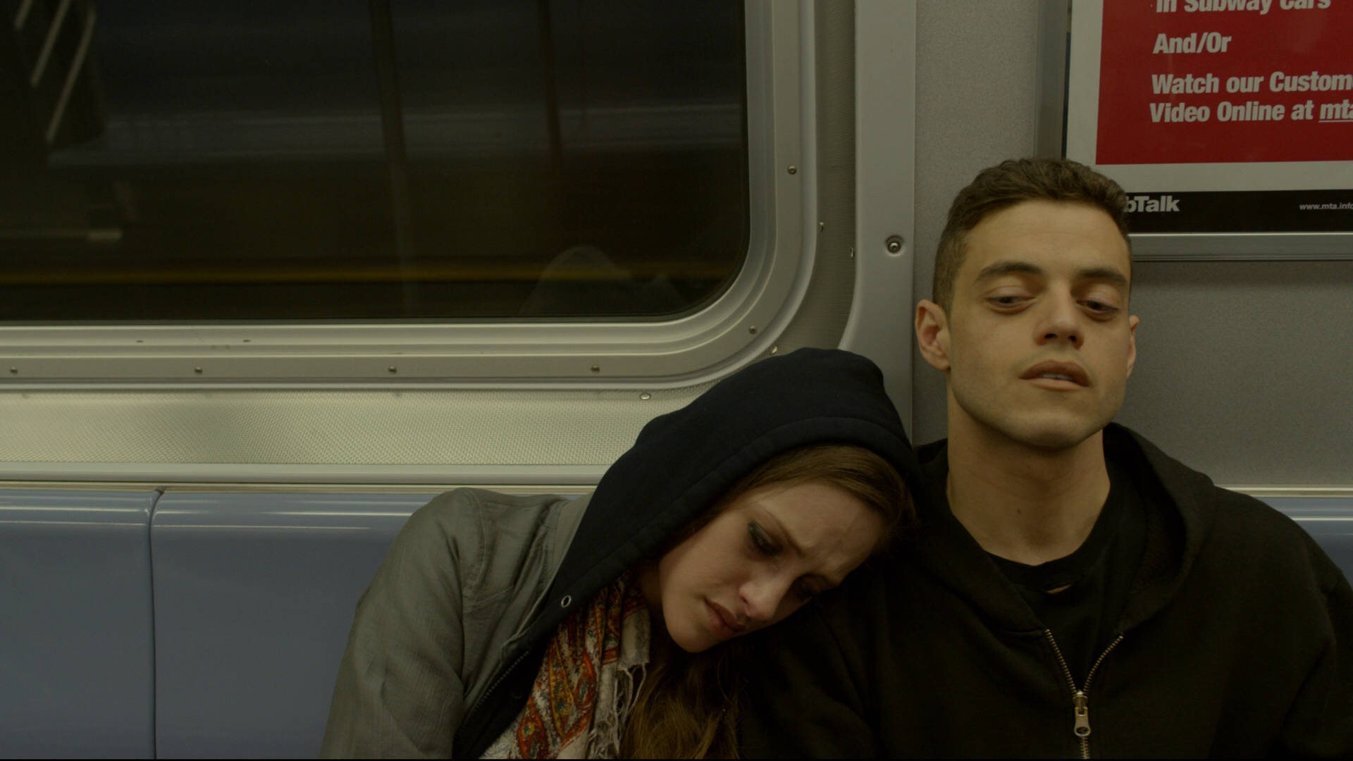 Rami Malek With Woman On Train Background