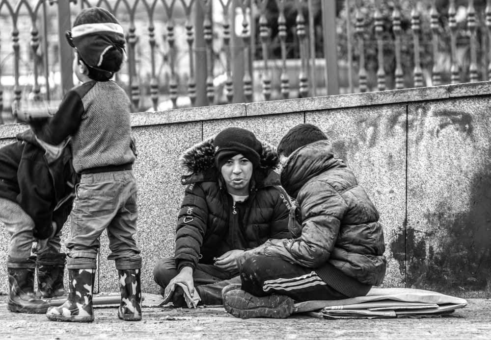 Random People Sitting On Sidewalk