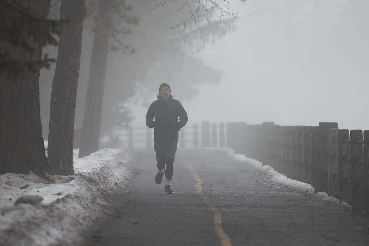 Random Person Jogging On Misty Road Background