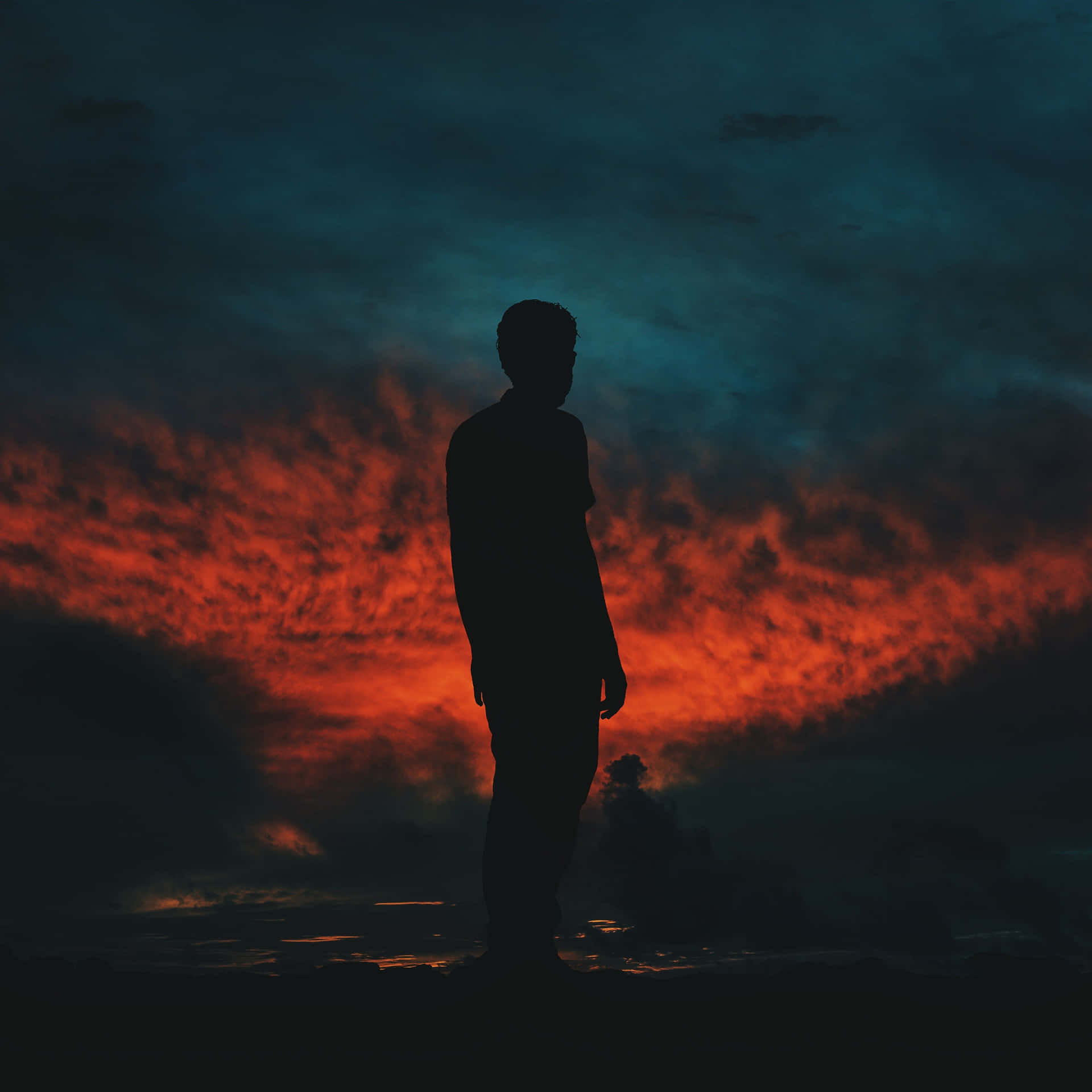 Random Person Silhouette Against Dark Sunset Sky