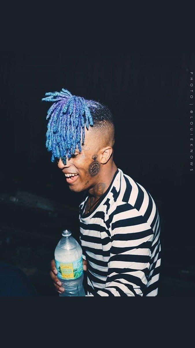 Rap Artist Xxxtentacion Poses For The Camera With Blue Hair. Background