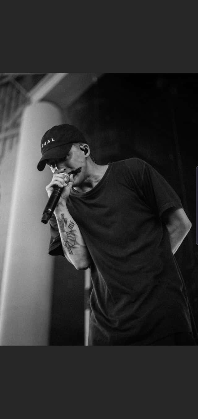 Rapper Nf Stands In A Valley Of Success Background