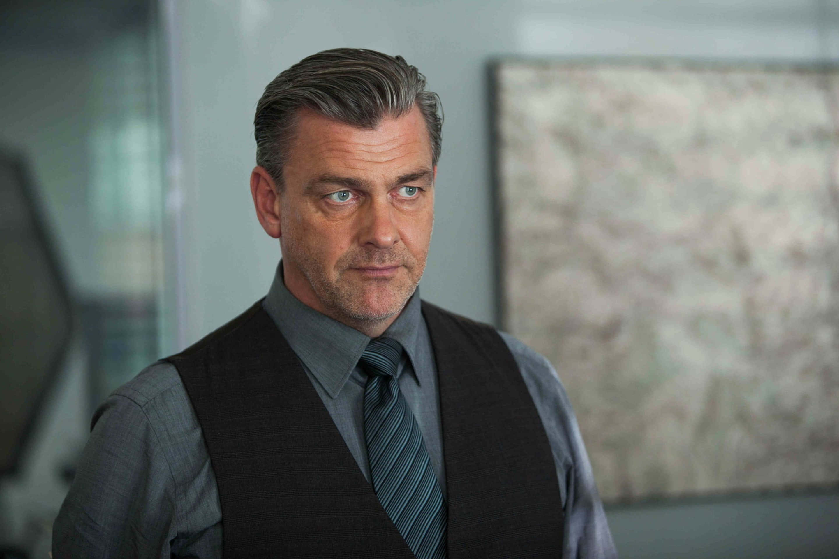 Ray Stevenson Looking Focused And Determined Background