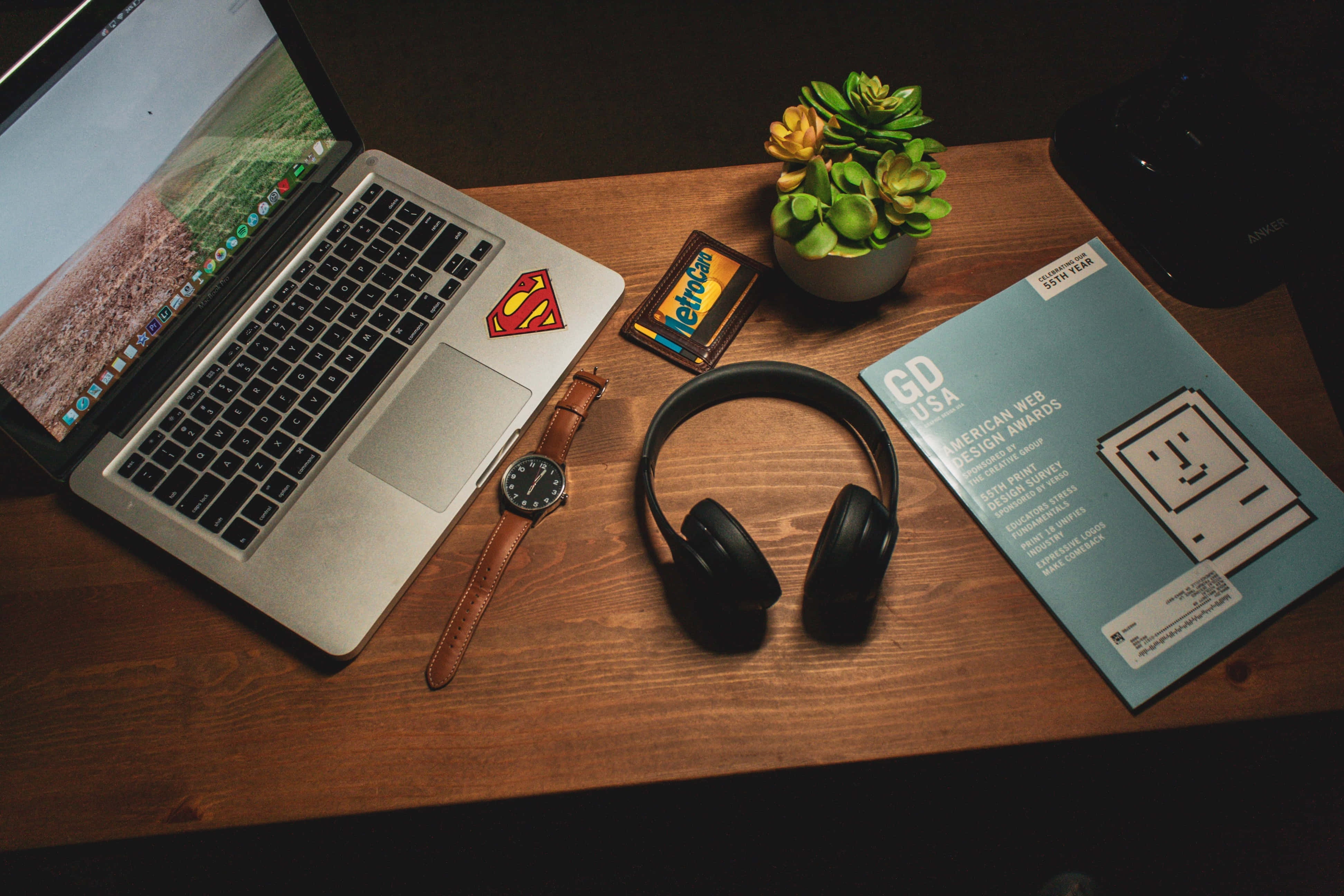 Red And Black Headphones Resting Atop A Silver Laptop. Background