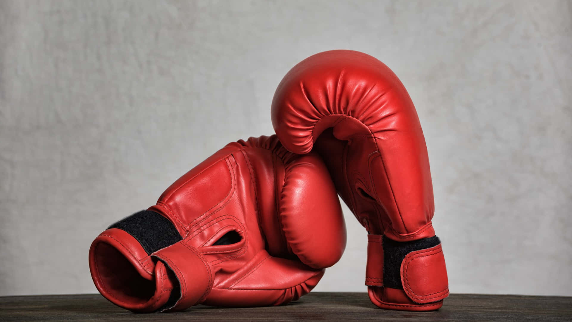 Red Boxing Gloves Restingon Wooden Surface Background