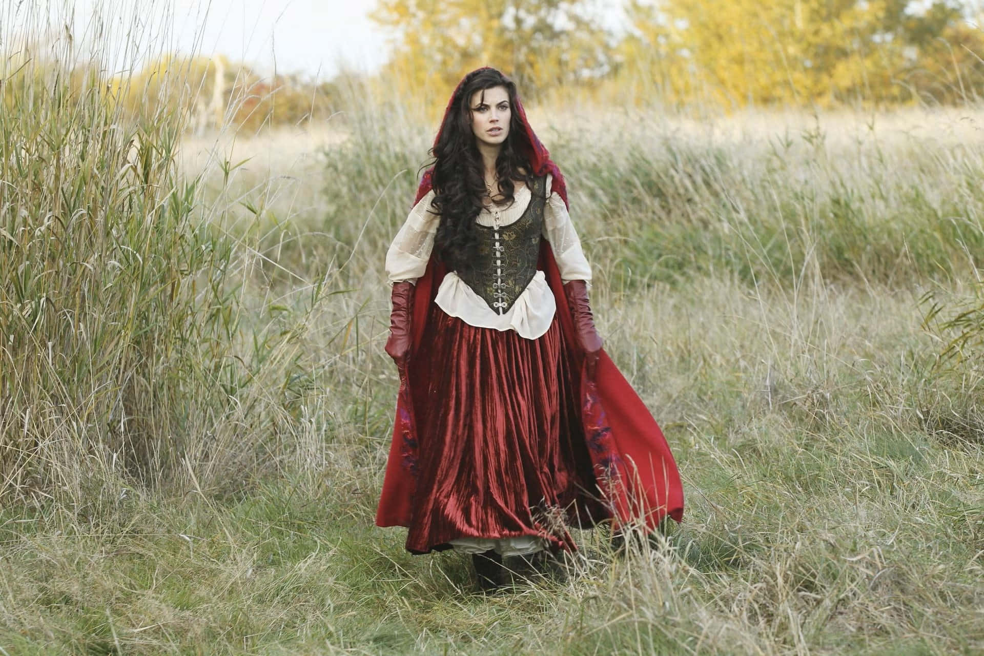 Red Cloaked Womanin Autumn Field Background