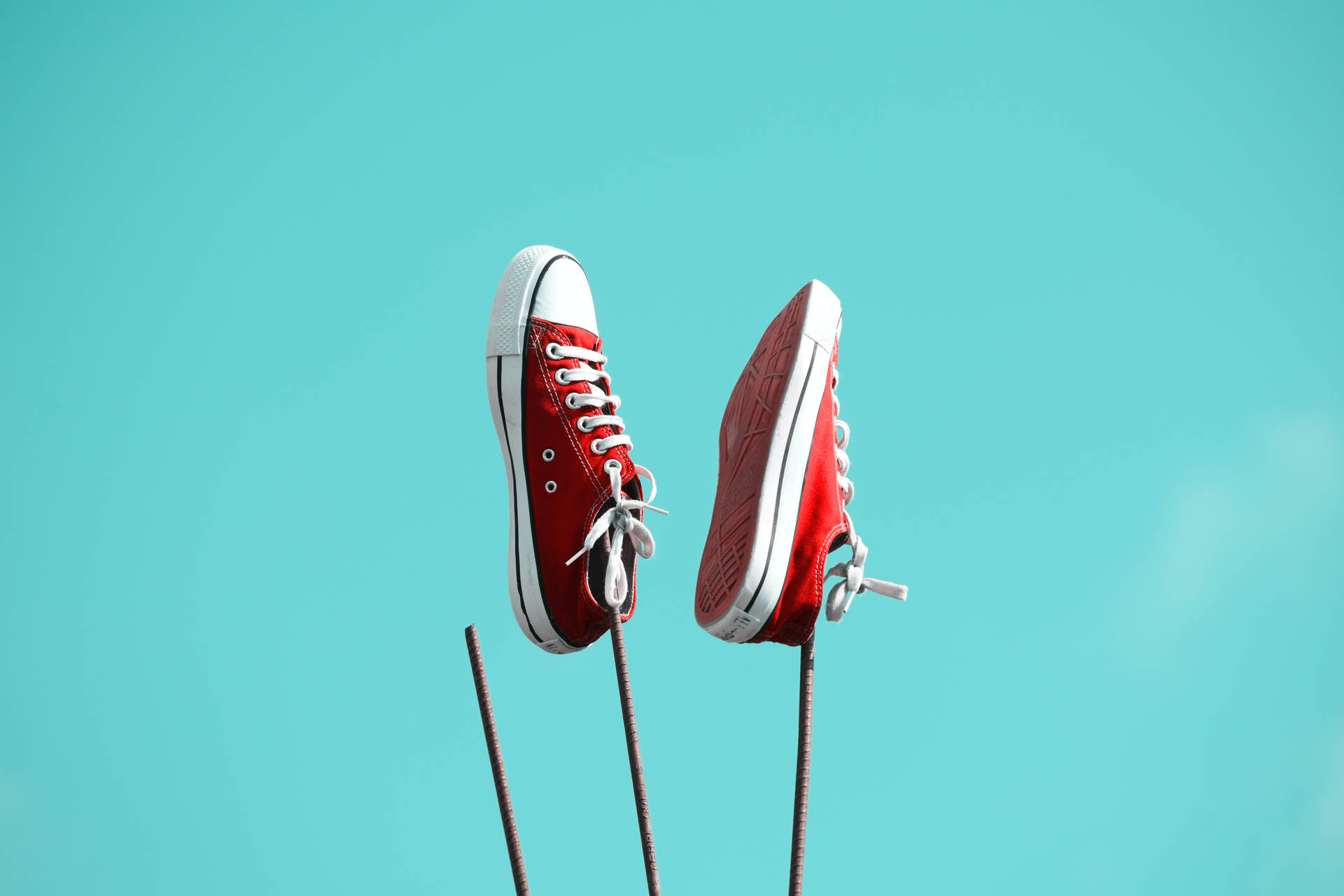 Red Converse Shoes Against Iron Bars Background