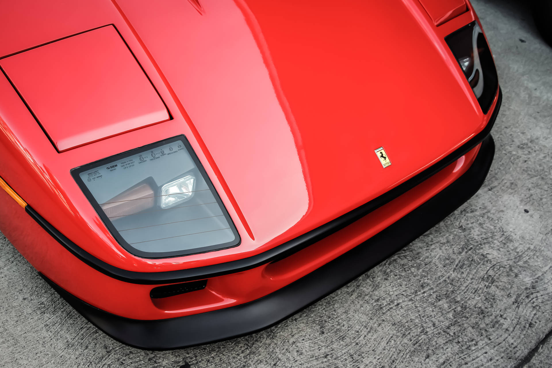 Red Ferrari Sports Car Silhouetted Against A Dramatic Sunset Background