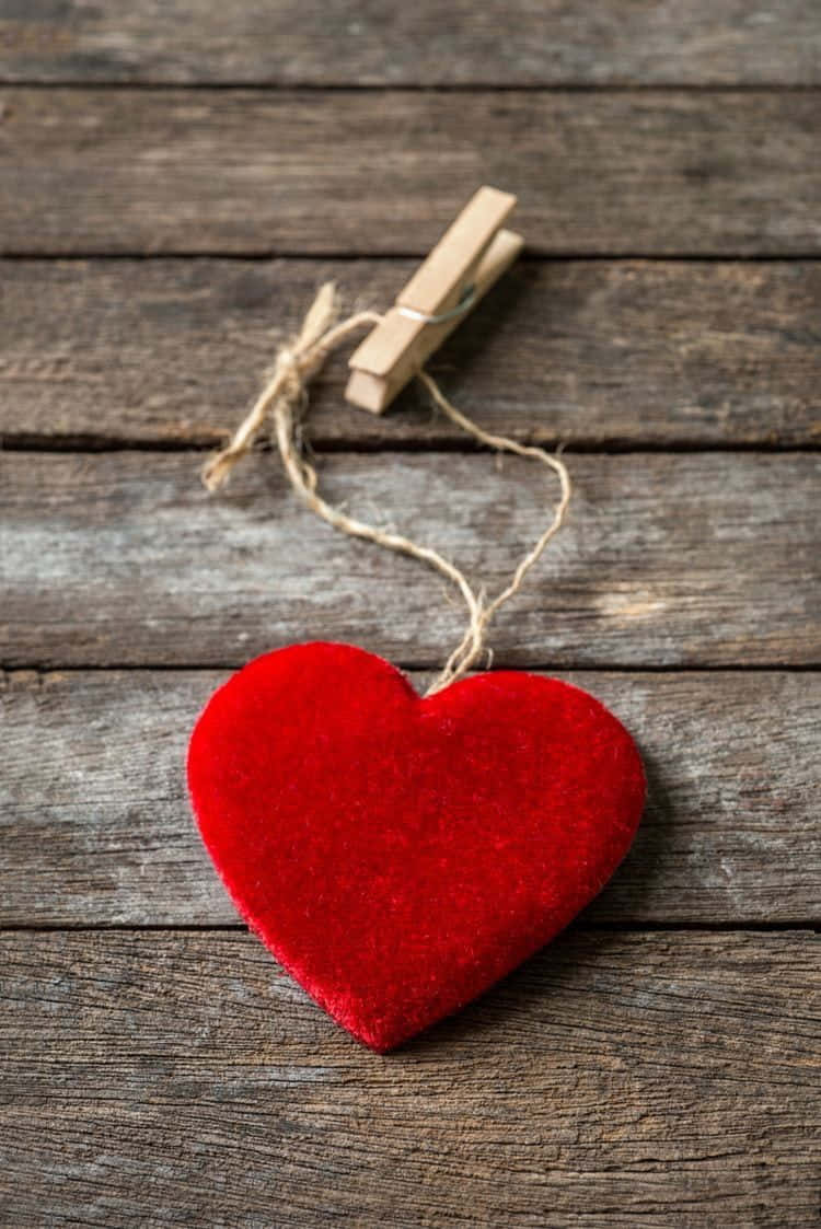 Red Heart Hanging On Wooden Background