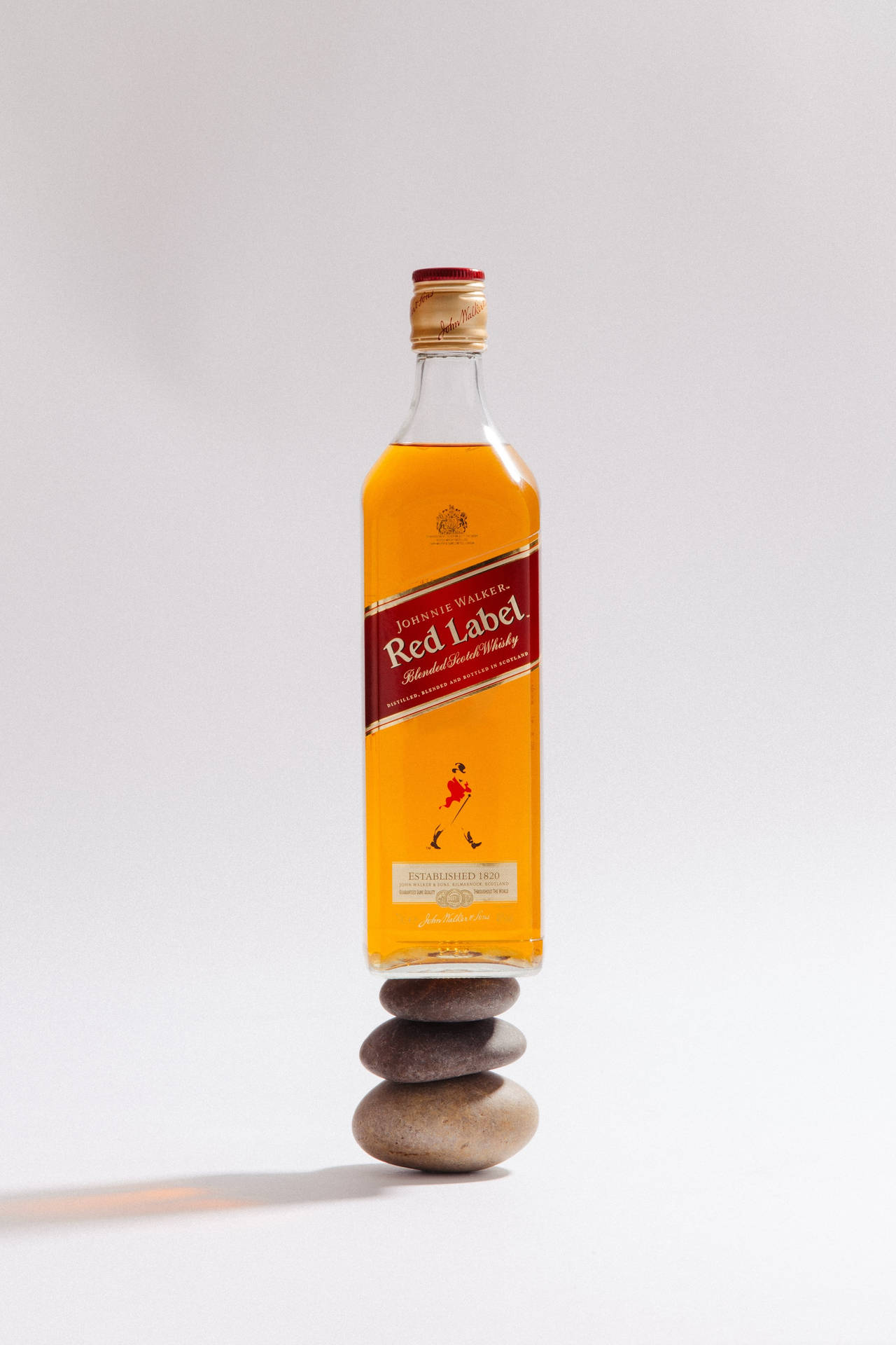 Red Label Whiskey Bottle On Stone Stack Background