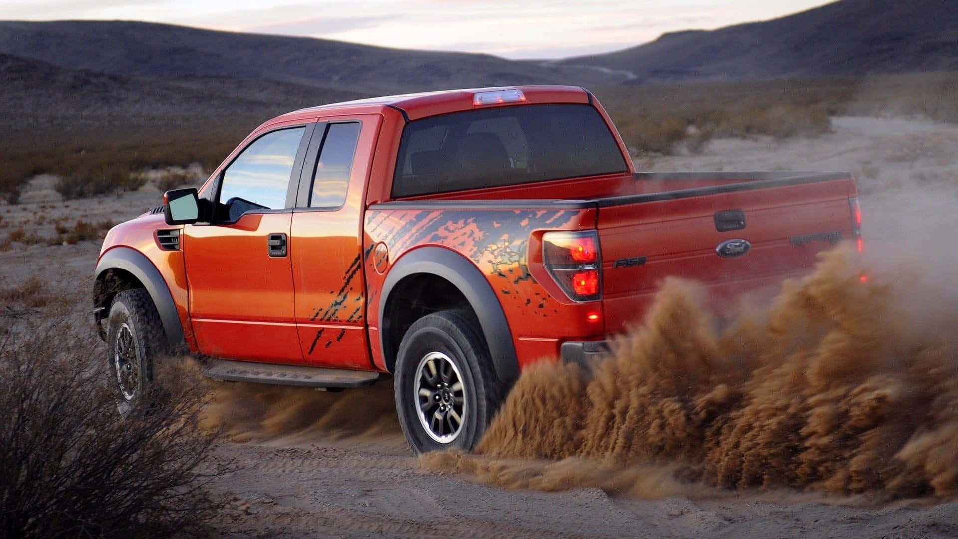 Red Lifted Truck Driving On Desert Background