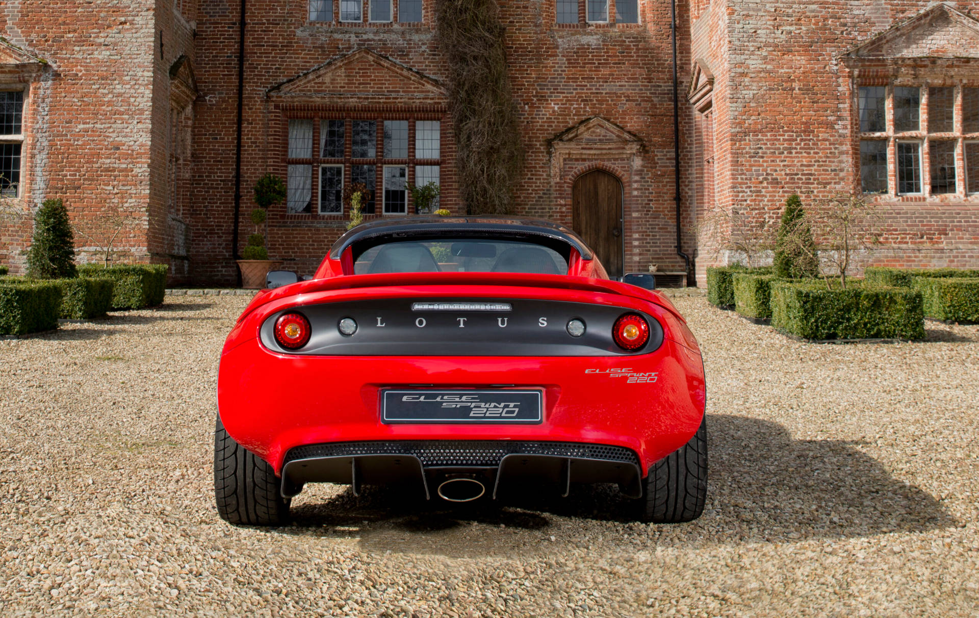 Red Lotus Car In A Red Brick Manor Background