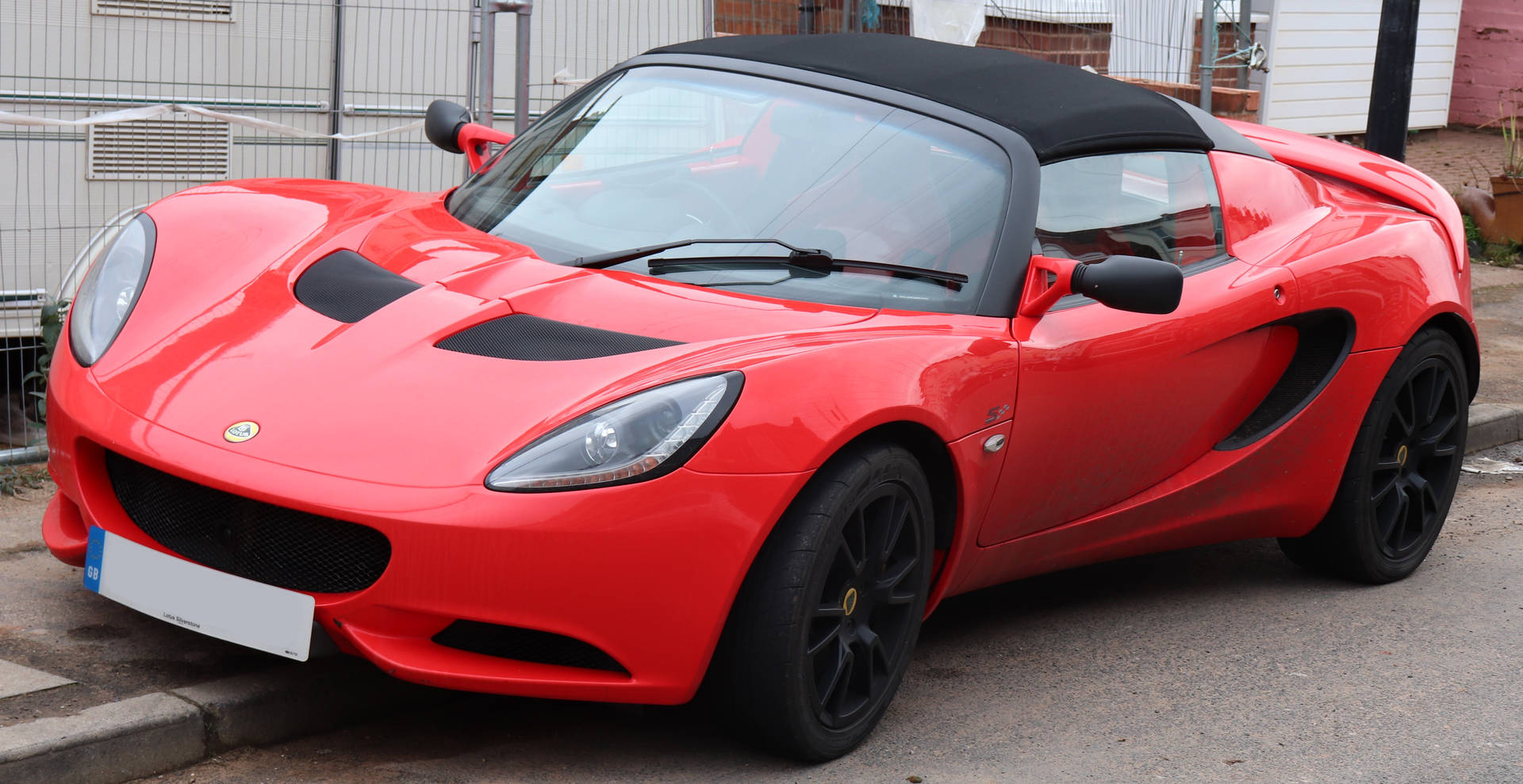 Red Lotus Elise Car Parked On Curb Background