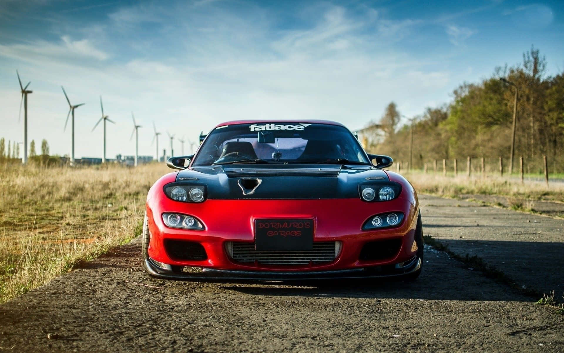 Red Mazda Rx 7 Against Windmill Background