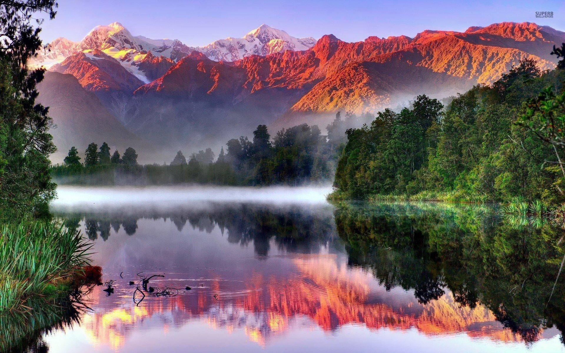 Red Rocky Mountain Over A Dark Green Forest Background