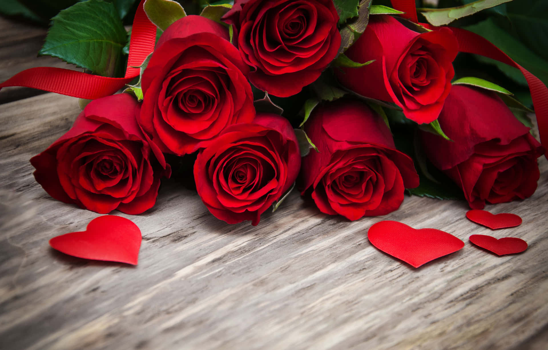 Red Roses With Hearts On A Wooden Table