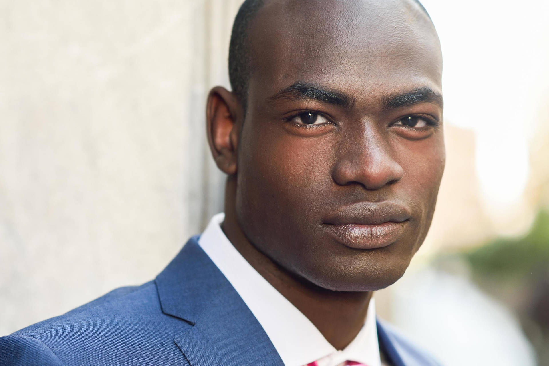 Refined Elegance: A Handsome Black Man In A Pink Blush Background