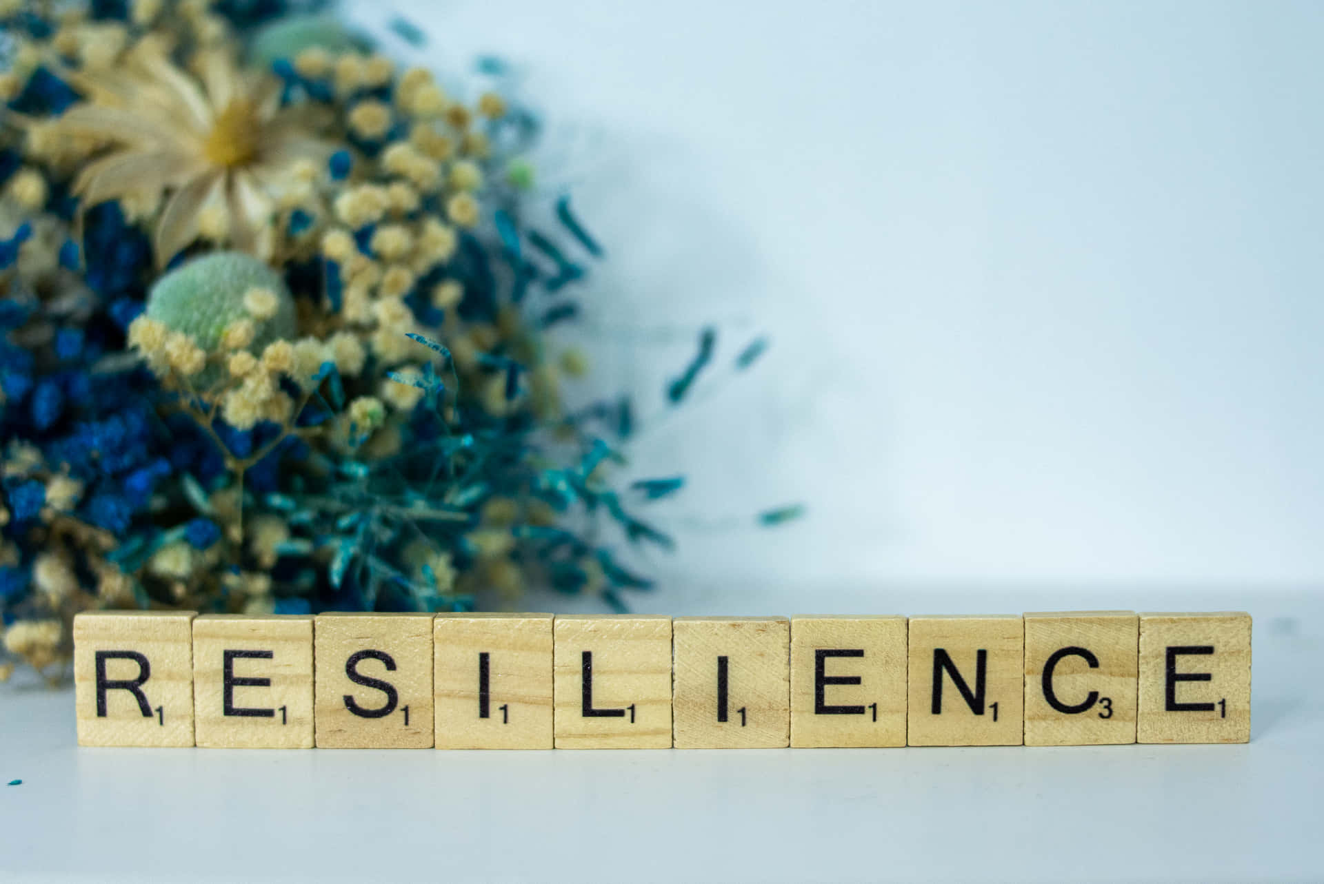 Reminder For People To Be Resilient In Scrabble Letter Tiles Background