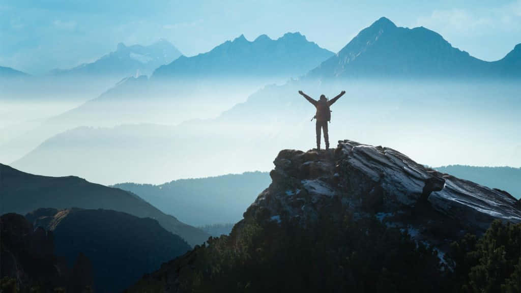 Resilient Person Conquering A Tall Mountain Background
