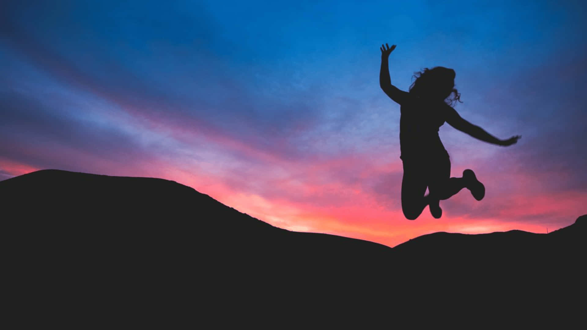 Resilient Woman Jumping In Joy Background