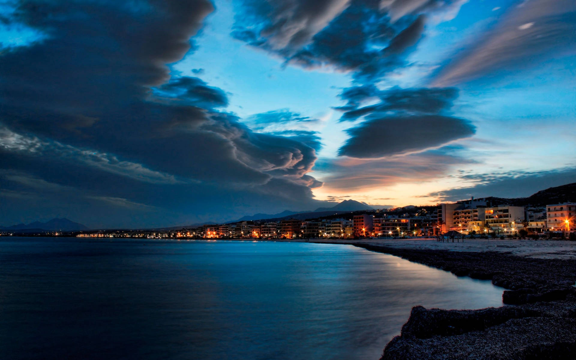 Rhythmic Waves Under Starry Night At Rethymno Beach Background