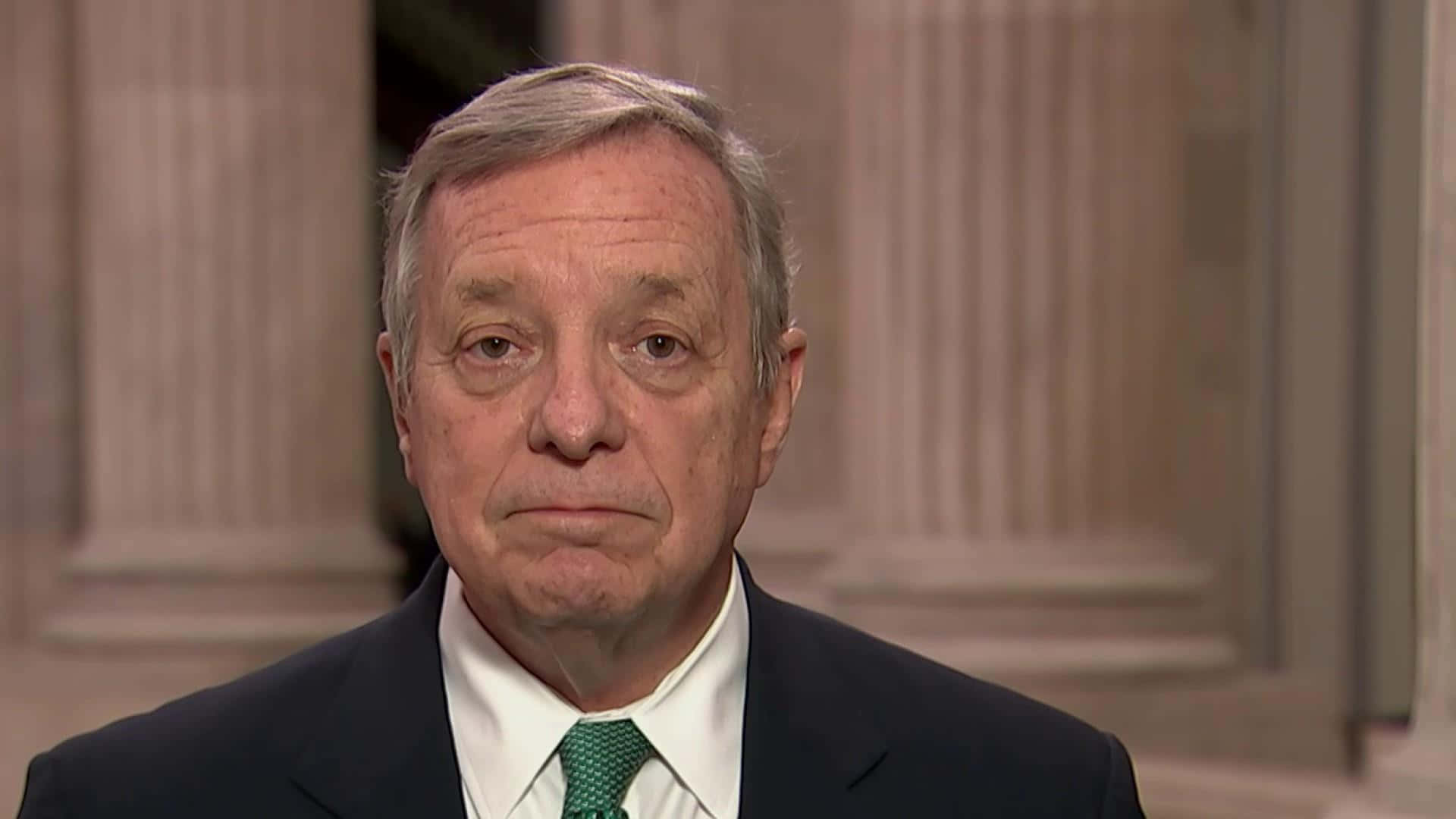 Richard Durbin Delivering A Speech With A Straight Face Background