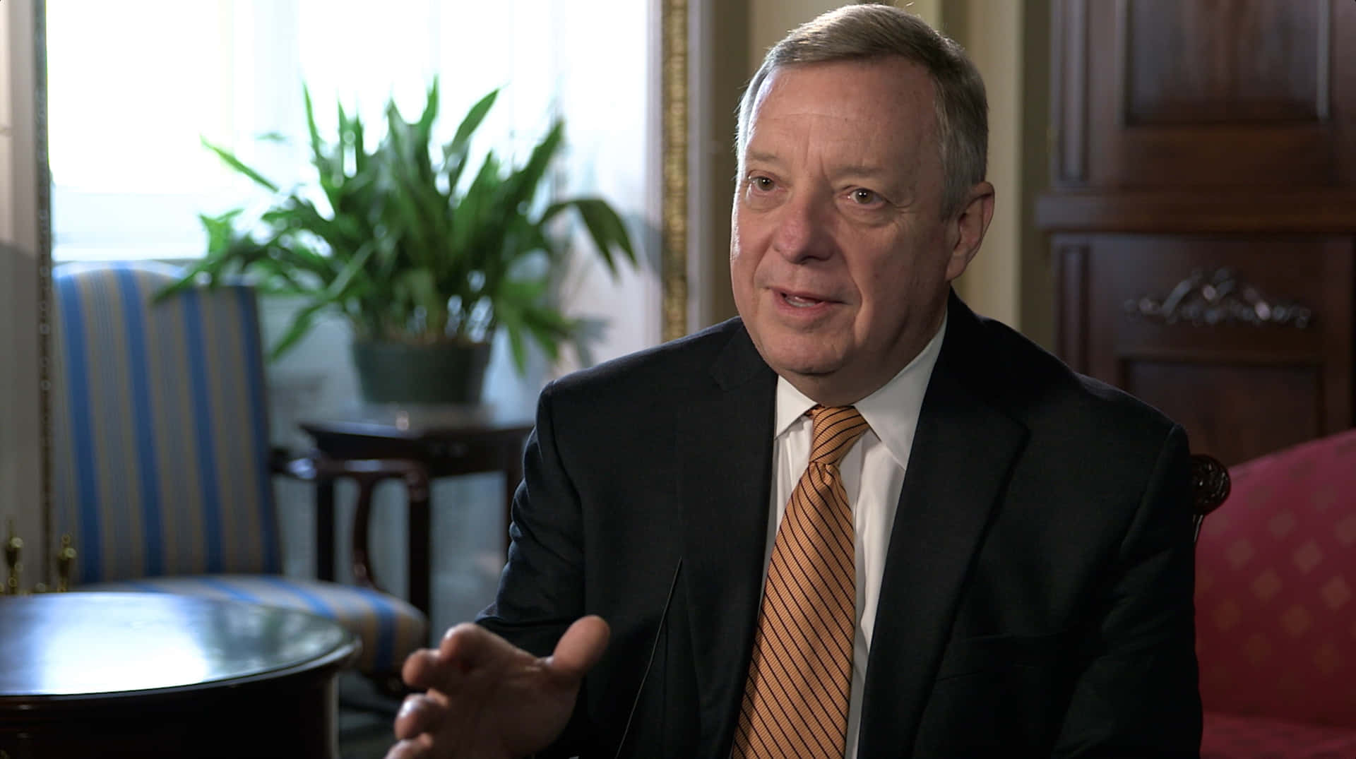 Richard Durbin Holding Out Right Hand Background