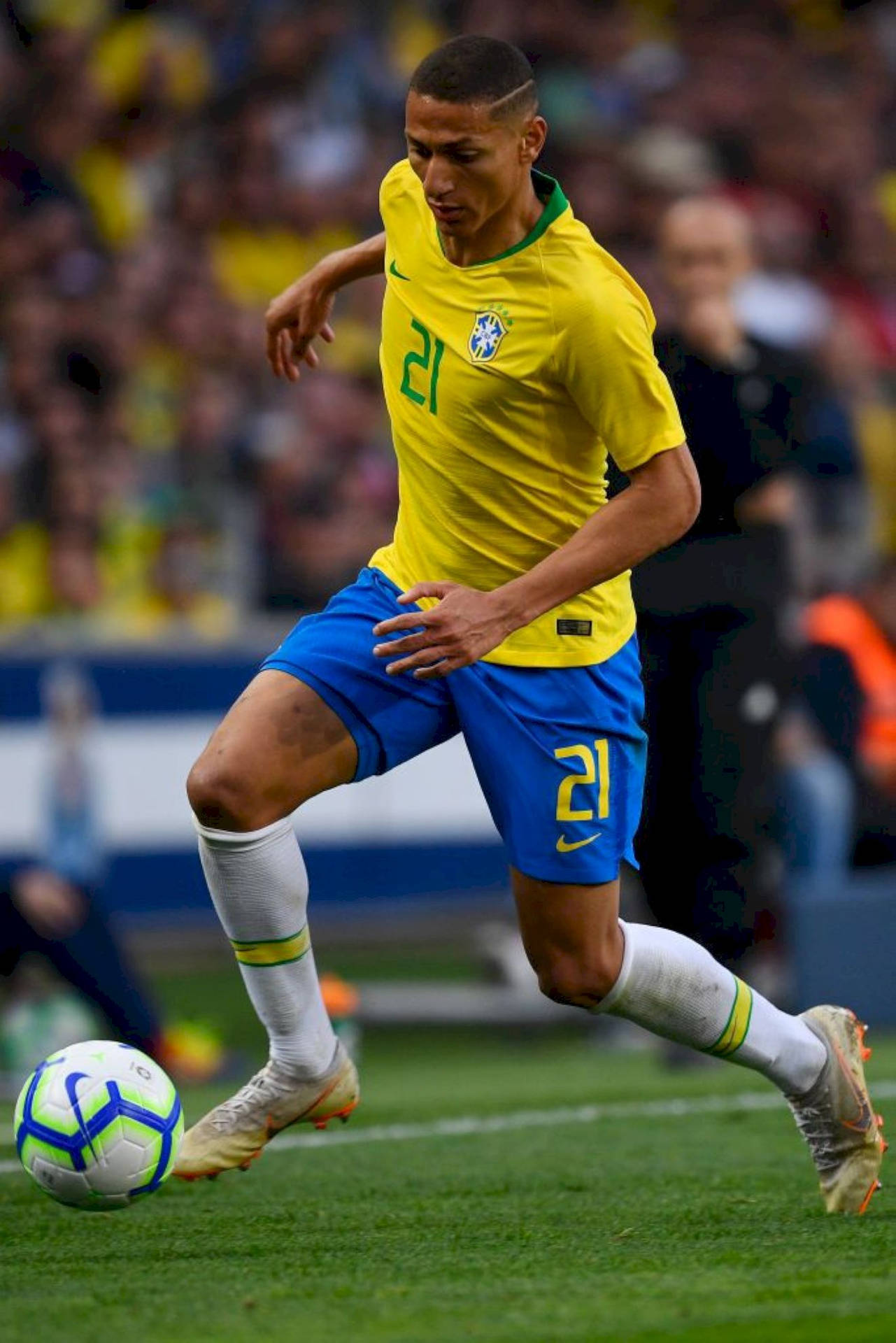 Richarlison De Andrade Skillfully Dribbling A Football During A Match Background