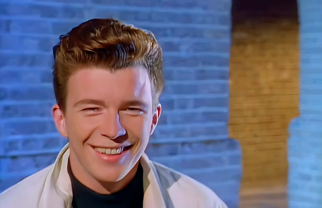 Rick Astley Performing At A Concert Background