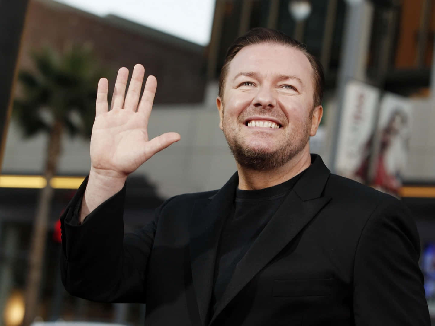 Ricky Gervais Smiling For A Photoshoot Background