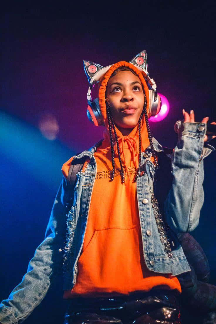 Rico Nasty Strikes A Pose In Her Iconic Bright Pink Hair Background