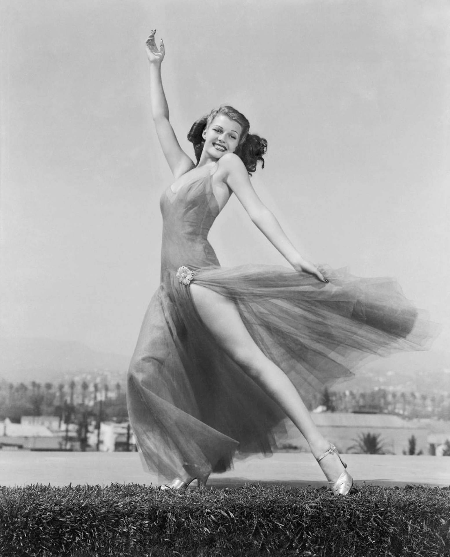 Rita Hayworth Dancing On Grass Background