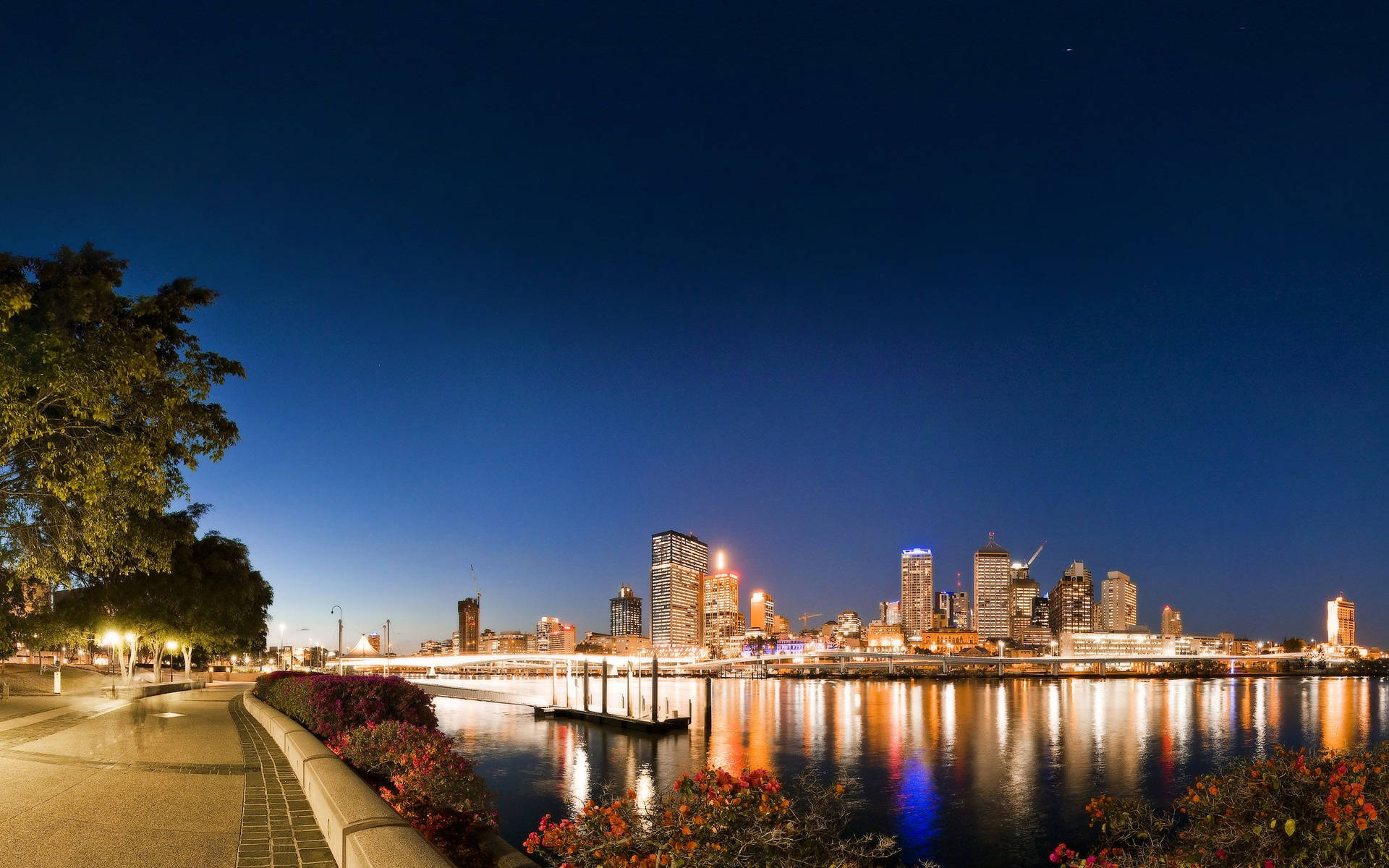 Riverside Concrete Walkway At Night Background